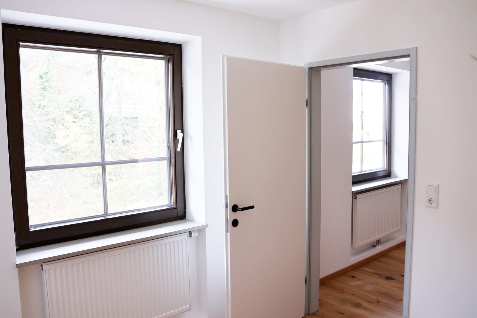 Helles Schlafzimmer mit Fenster ins Grüne